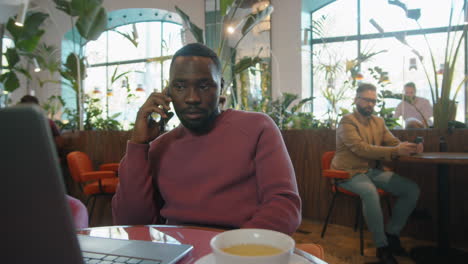 Black-Businessman-Talking-on-Phone-in-Cafe